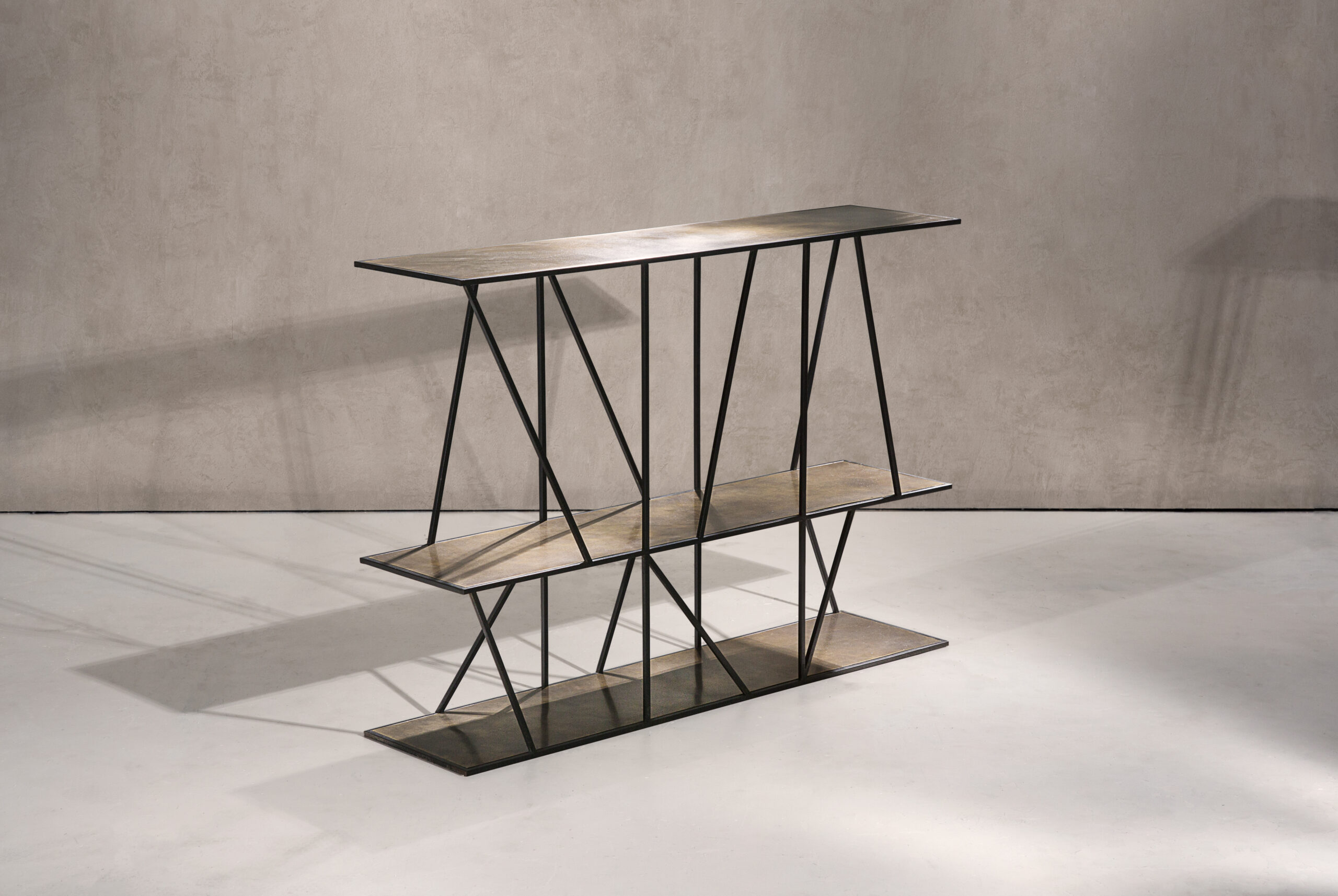 A sculptural console table in black patinated steel and patinated brass.