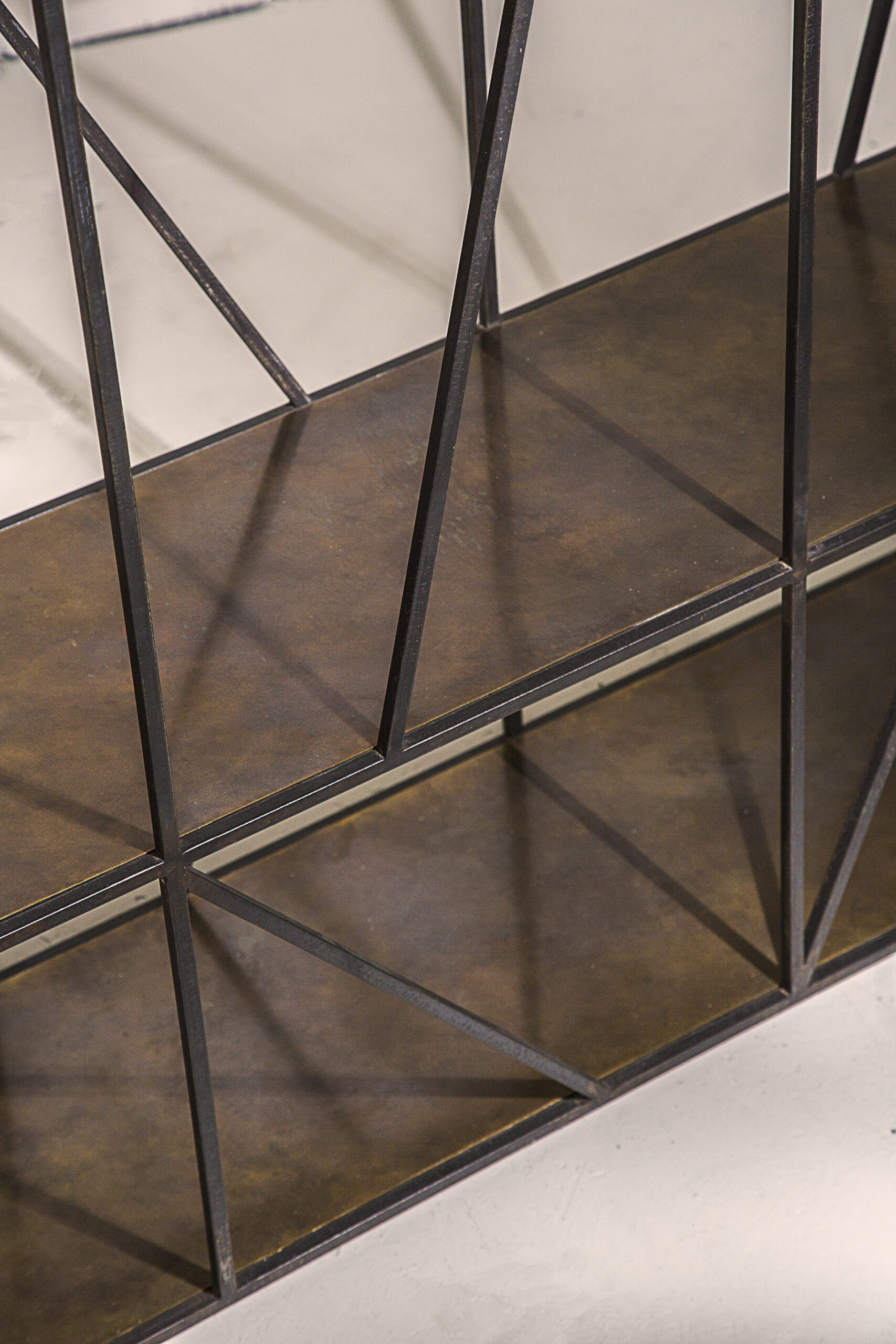 A sculptural console table in black patinated steel and patinated brass.